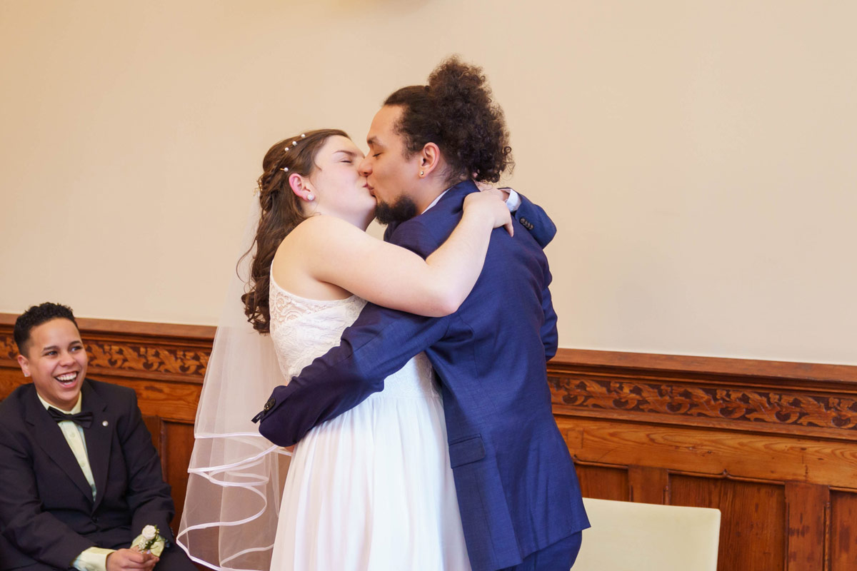 Hochzeitspaar teilt einen innigen Kuss im Standesamt Rathaus Lichtenberg, Berlin.