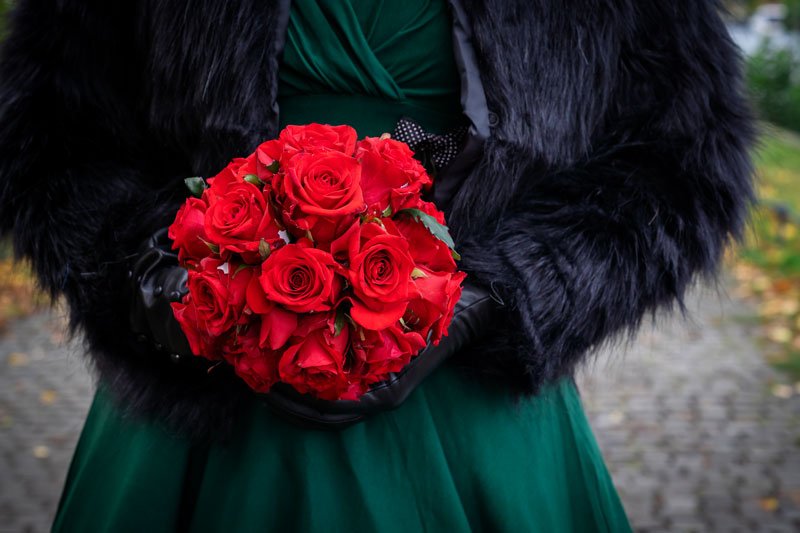 Roter Hochzeitsstrauß Brautstrauß aus Rosen, getragen von der Braut.